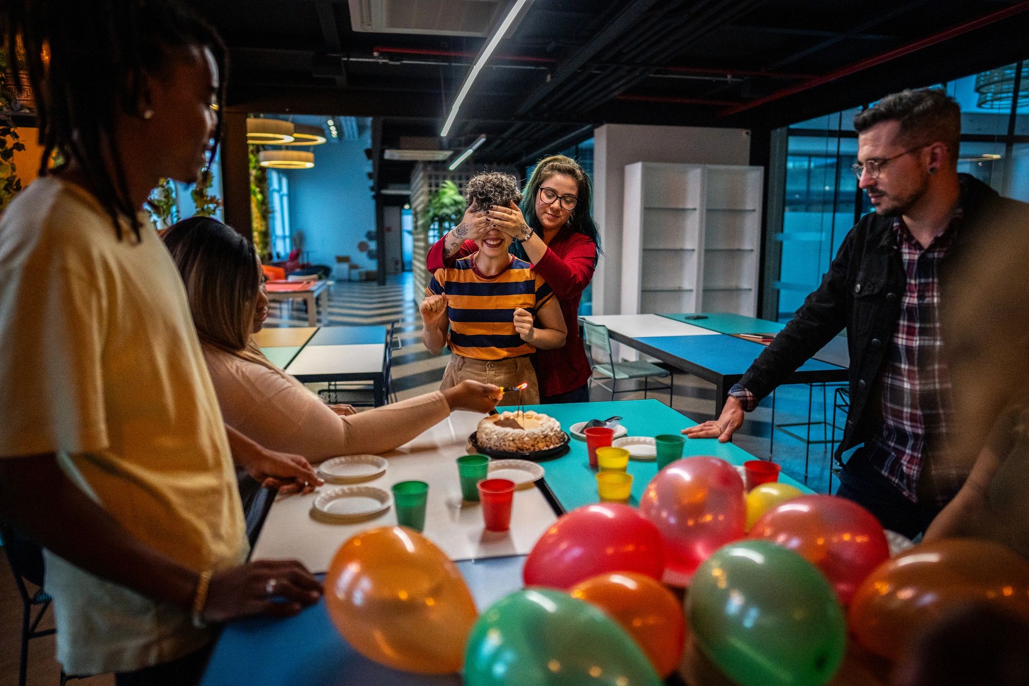 Friends preparing a surprise celebration in a party room